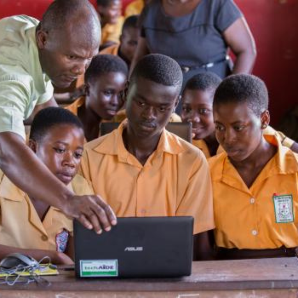 A Nigerian teacher conducting an online lesson via a laptop for students.