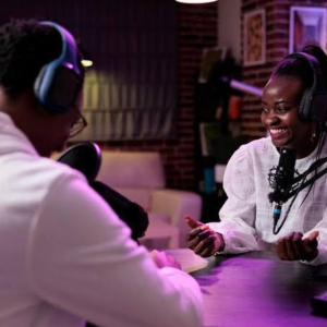 A Nigerian youth using a smartphone and microphone to record a podcast.