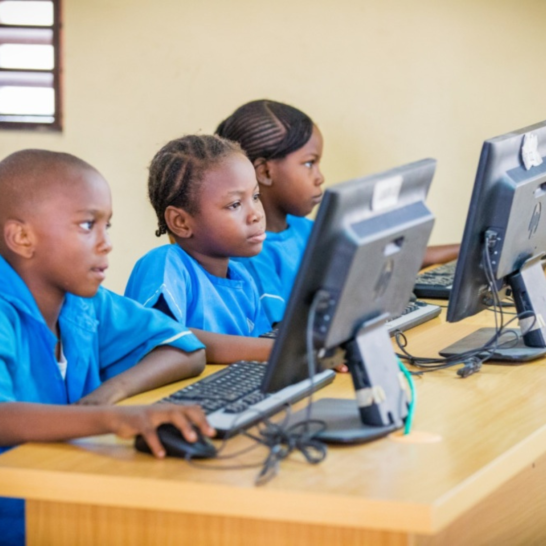 A modern library in an underserved Nigerian community with young people using computers.