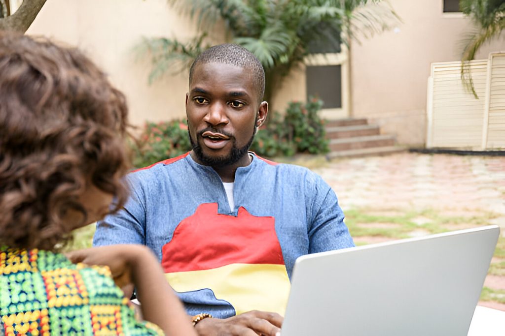 A young Nigerian entrepreneur using a laptop to sell handmade goods online